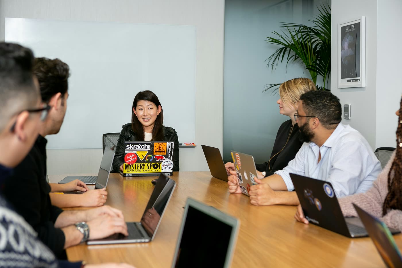 Réunion de travail autour d’une table, ordinateurs ouverts