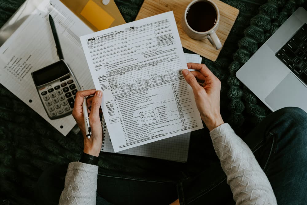 Document de travail chiffré annoté à la main sur un bureau